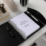 Open planner with sunglasses on a desk