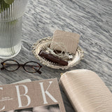 Book titled 'CBK' on a marble surface with flowers and coffee.