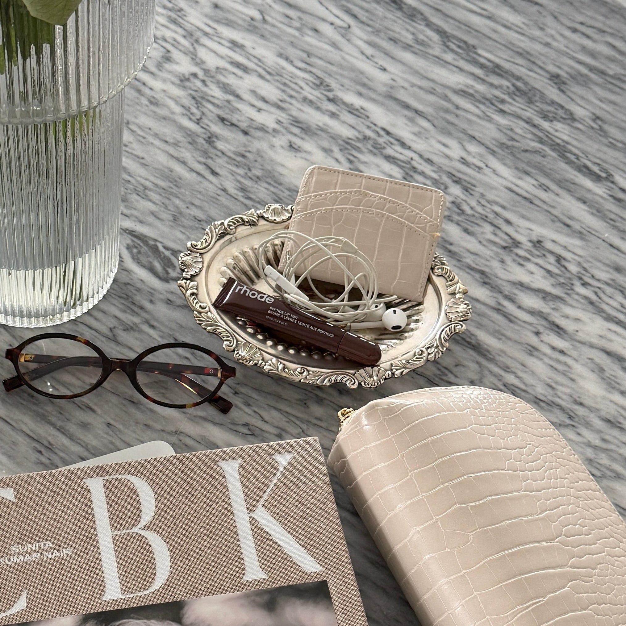 Book titled 'CBK' on a marble surface with flowers and coffee.